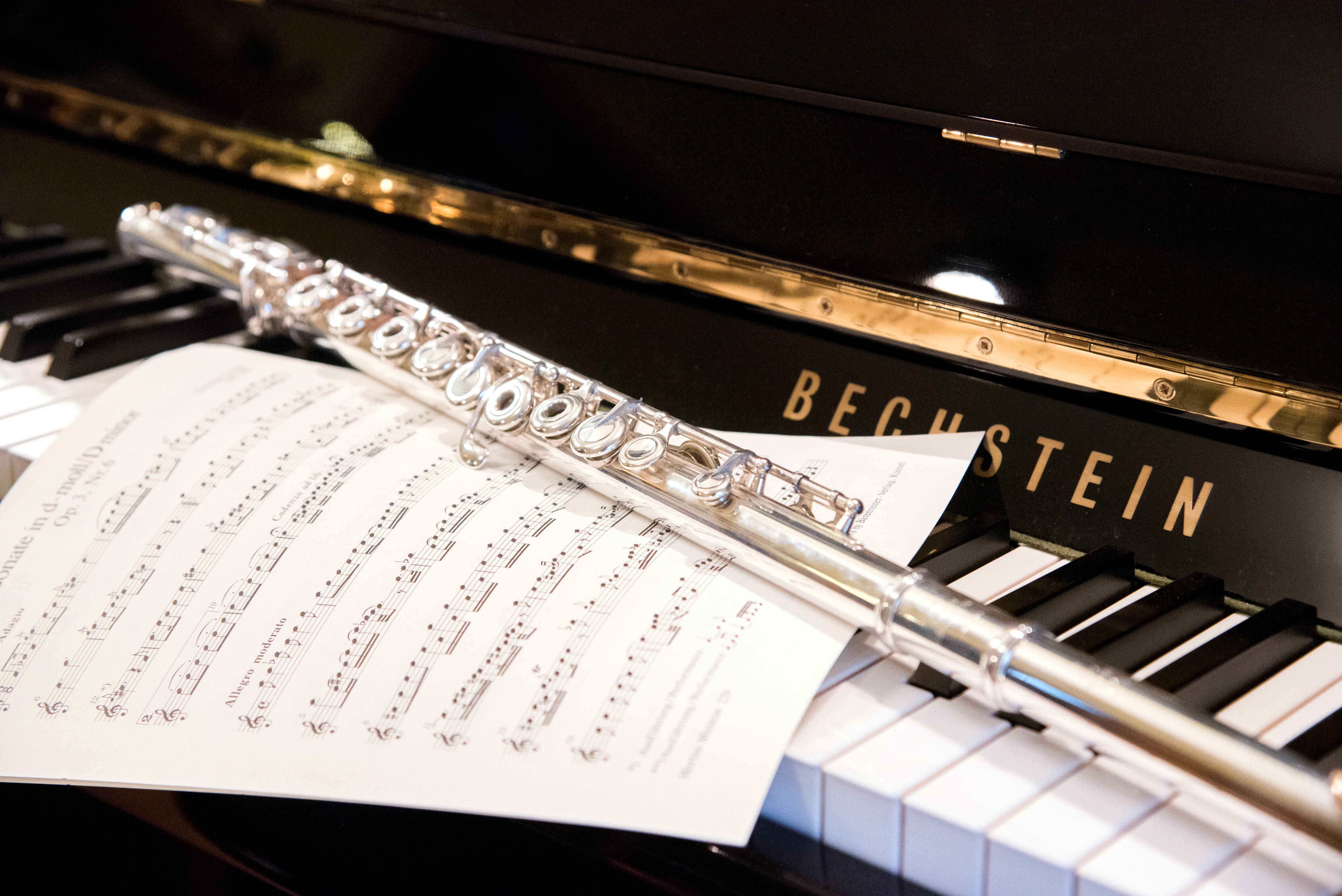 Querflöte und Noten auf Klaviatur eins Klaviers